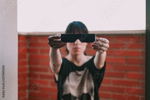 Una mujer sujeta unas gafas negras para ver un eclipse. Protección solar para la observación segura de un eclipse total. Accesorio para observar el eclipse de agosto de 2026 en España