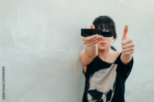 Una mujer sujeta unas gafas negras para ver un eclipse. mientras hace el gesto de ok con la mano. Protección solar para la observación segura de un eclipse total. 