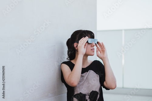 Una mujer sujeta unas gafas negras para ver un eclipse. Protección solar para la observación segura de un eclipse total. Accesorio para observar el eclipse de agosto de 2026 en España