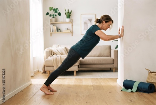 Woman Performing Wall Push-up Exercise in Modern Living Room, Beginner At-Home Fitness and Wellness Concept