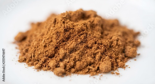 Macro Close-up of Ground Cinnamon Powder on White Background, Culinary Ingredient and Baking Concept