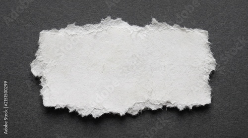 Torn paper on a dark gray background with a blank white space for text