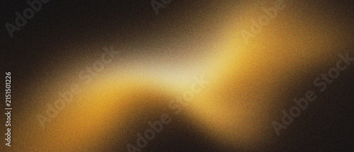 Abstract golden light leak with grainy film texture on black background. Warm amber glow and soft ethereal blur. Cinematic vintage light overlay for creative photography and moody design work.