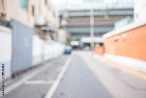 Abstract blurred urban residential street background with orange wall and overpass