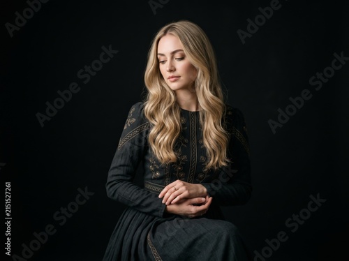 Contemplative Blonde Woman Wearing Elegant Black Evening Gown
