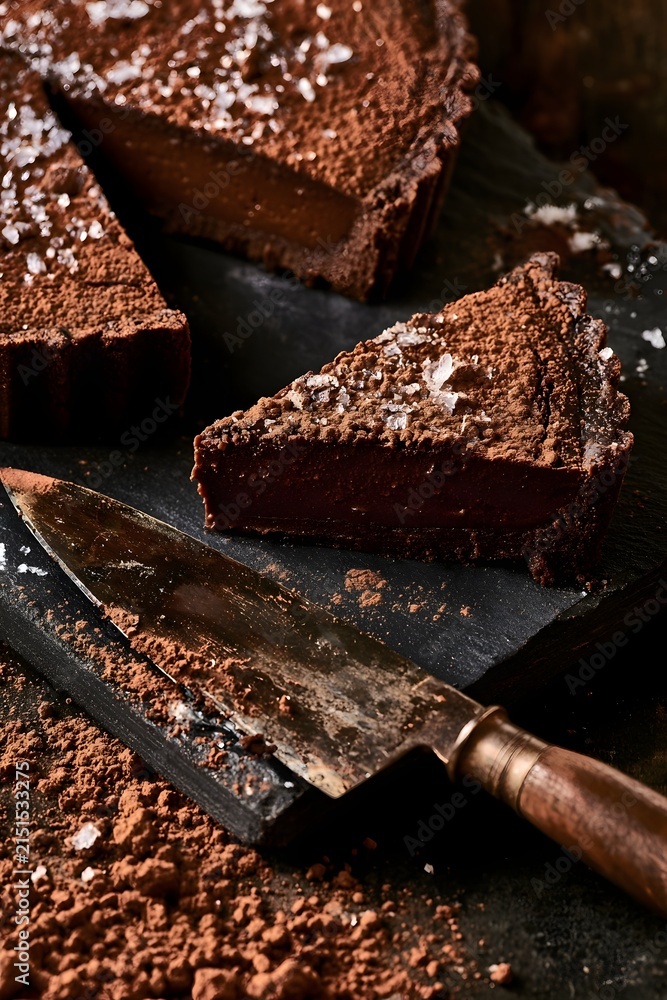 Fototapeta premium Rustic Dark Chocolate Tart with Sea Salt on Slate Board