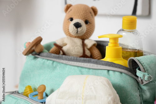 Baby bag with accessories in room, closeup