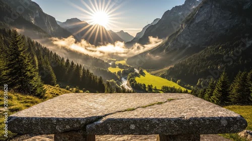Stone table overlooking misty mountains at sunrise.