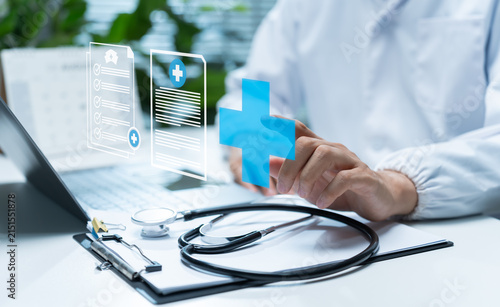 Doctor manages digital health records with medical interface, laptop and stethoscope, representing electronic patient, clinical documentation, healthcare technology and hospital information systems.
