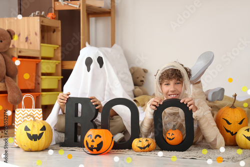 Foto Children in Halloween costumes holding boo letters with pumpkins