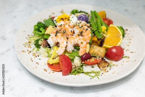 Принти на полотні A nutritious fresh salad with cooked shrimp, hard-boiled egg, assorted vegetables, and grains served on a speckled plate