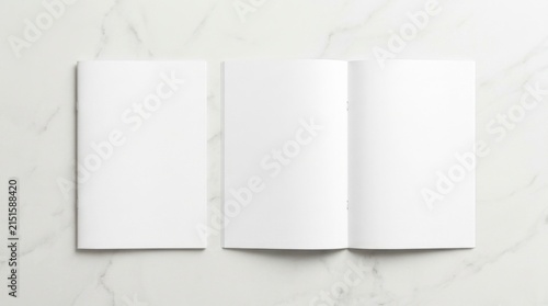 Blank white booklet mockup set featuring an open spread and closed cover on a clean white marble background, ideal for magazine, brochure, or catalog branding and print layout presentations.