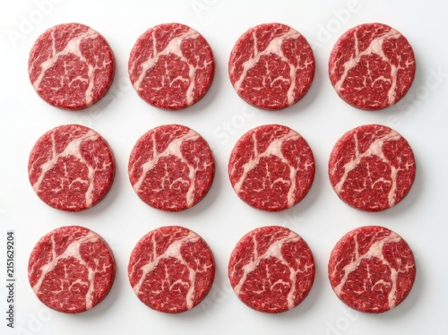 A perfectly arranged grid of twelve raw circular wagyu beef steak patties