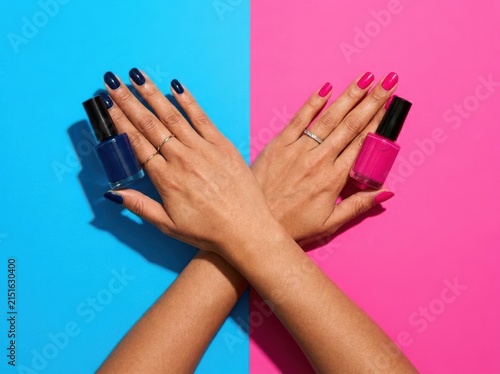 Woman crossing arms holding blue and pink nail polish on split background