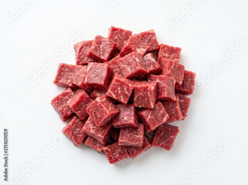 A pile of fresh raw beef cubes isolated on a white background