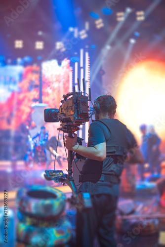 Картината върху платно Steadicam operator filming live performance on stage with camera stabilizer and
