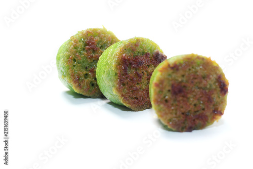 Foto Three toasted green pandan cakes lined up diagonally on a white surface with shallow depth of field