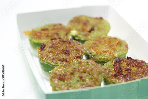 close-up view of six toasted green pandan cakes displayed inside an open paper box.