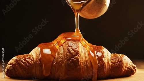 Freshly Baked Croissant Drizzled with Warm Honey on Dark Background - Gourmet Breakfast Delight Captured in Close Up
