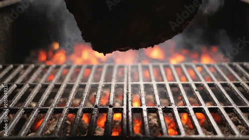 Grilling Perfect Steak With Tongs Over Glowing Embers And Smoke Capturing Juicy Flame-Grilled Perfection Ideal For Culinary Masterpieces