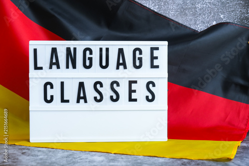 Lightbox with text LANGUAGE CLASSES National symbol of Germany. German wave silky flag background. Concept of education and learning 