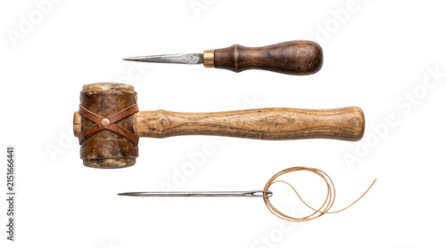 Vintage leatherworking tools set, antique rawhide mallet and awl on white background, traditional saddlery equipment for leather craft