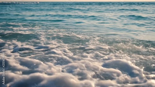 Gentle Ocean Wave Breaking on Sandy Shore Under Sunlight