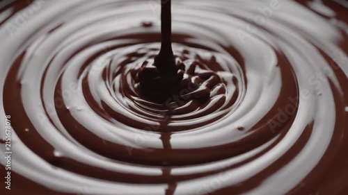 Rich dark chocolate sauce swirling in slow motion macro view, a decadent visual delight.