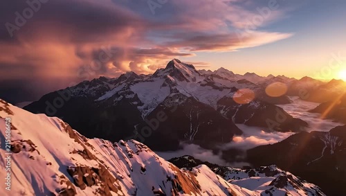 Panoramic view of snowy mountains at warm winter sunset.