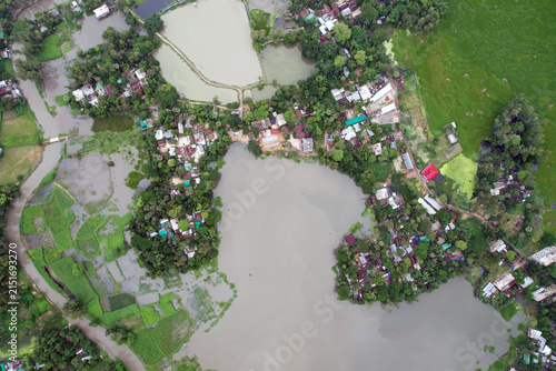Canvas Print Aerial view of a densely populated rural settlement beside a murky river