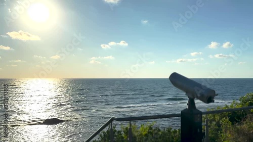 Sightseeing binoculars overlooking the sea at sunrise, panoramic ocean horizon view from an empty coastal observation deck, peaceful golden morning landscape. Scene B.