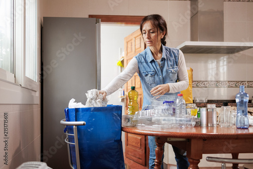 Woman recycling household waste sorting paper and plastic