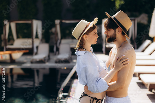 Foto Happy couple embracing by swimming pool at resort