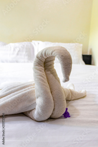 Towel Swan With Tropical Flower On Hotel Bed In Thai Hotel Room.