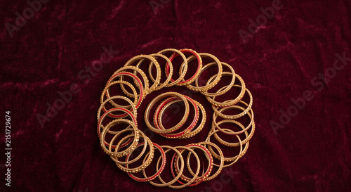 Traditional red and gold Indian bangles arranged on rich velvet background for bridal jewelry, wedding fashion and festive cultural themes