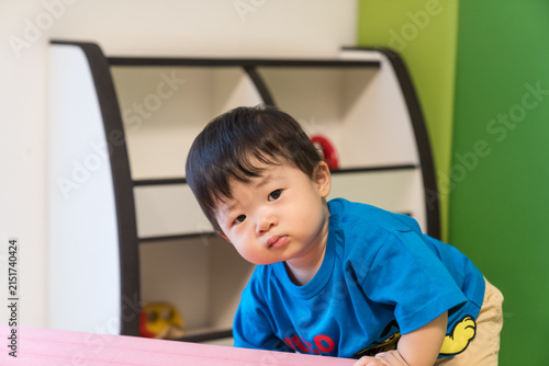 Foto キッズルームのピンクのソフトブロックにもたれている日本人の男の赤ちゃん