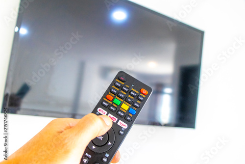 Hand Holding Remote Control Turning On Television In Thai Hotel Room Thailand.
