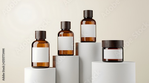 Four amber glass bottles and jars with blank labels on white pedestals.