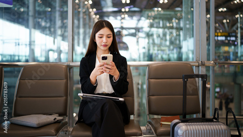 Foto Airport phone travel woman using mobile phone in business class lounge waiting for plane flight texting sms message on smartphone