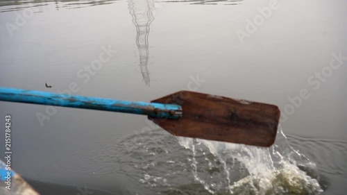 Wooden oar rowing a boat in calm river water with ripples and reflection in Delhi NCR India