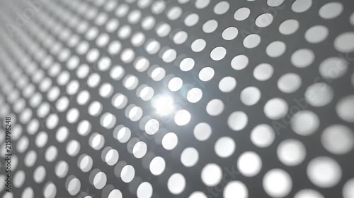 A close up view of a dark metal sheet with circular holes