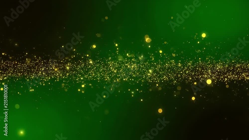 Golden dust particles in motion against a dark green gradient background with subtle light flares