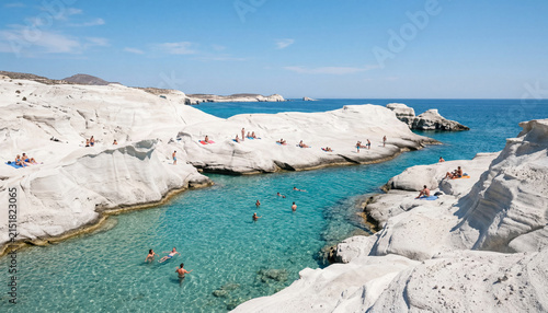 Sarakiniko beach Milos Greece photography of white volcanic rock formations and turquoise sea with tourists for Greek island travel advertising, summer vacation website banner, and Mediterranean resor