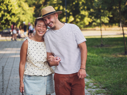 Foto Warm evening light surrounds a joyful couple as they walk through a quiet park together