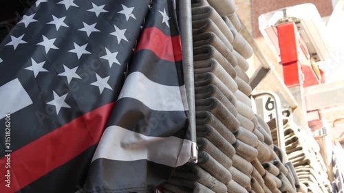 Red thin line black american flag on firefighter truck. Hose of firetruck and fire fighters symbol in New York, United States. 911 remembrance, fire department engine vehicle. September 11 Patriot Day