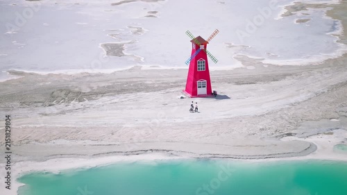 Aerial Panoramic View of Red Windmill Landmark in Dachaidan Emerald Lake: Colorful Salt Ponds, White Salt Crust and Azure Water in Qinghai