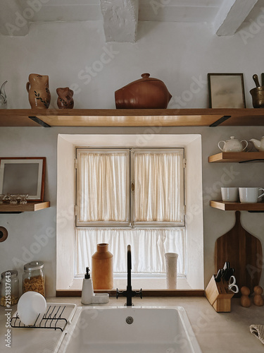 Bright rustic kitchen with wood accents, soft natural light, warm Mediterranean aesthetic and clean minimal style