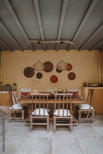 Rustic outdoor dining area, rattan chairs and warm natural tones, cozy Mediterranean-inspired patio design