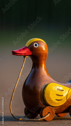 Wooden duck toy with a string on a smooth surface.