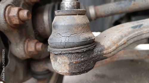 Close-up of worn automotive steering tie rod end with cracked rubber dust boot